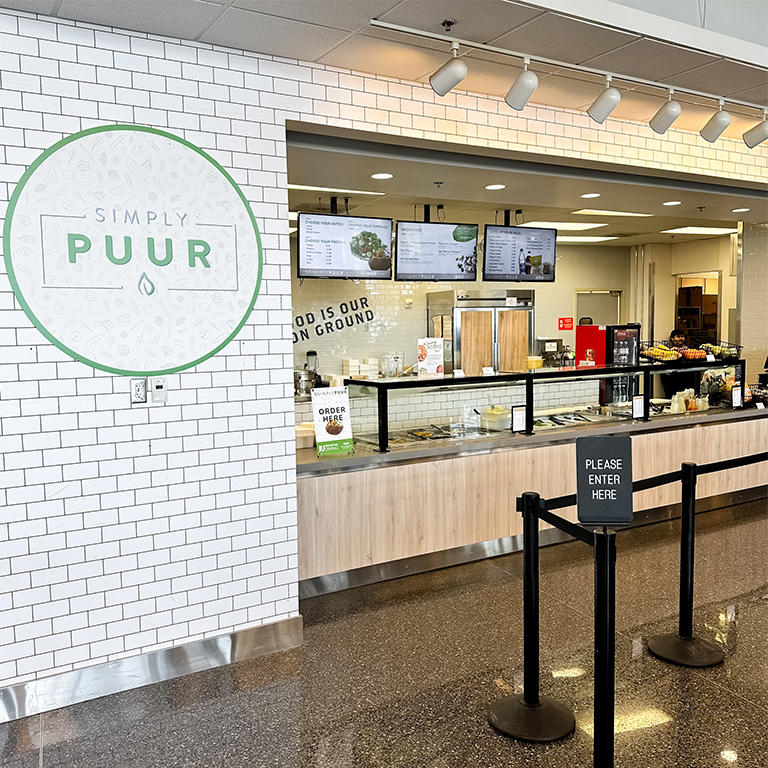 Photo of the Simply PUUR logo beside their new location in the Campus Center.